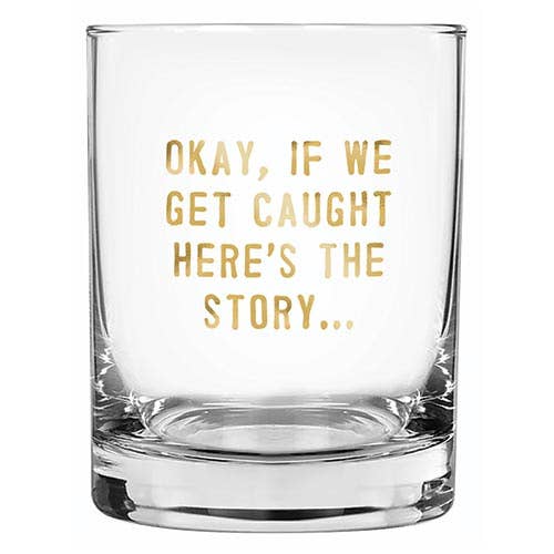 A clear glass tumbler with the text 'Okay, if we get caught here's the story.' printed in gold.